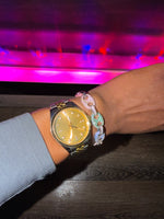 Gold dial mixed metal wristwatch on a wrist with coffee bean  bracelet 