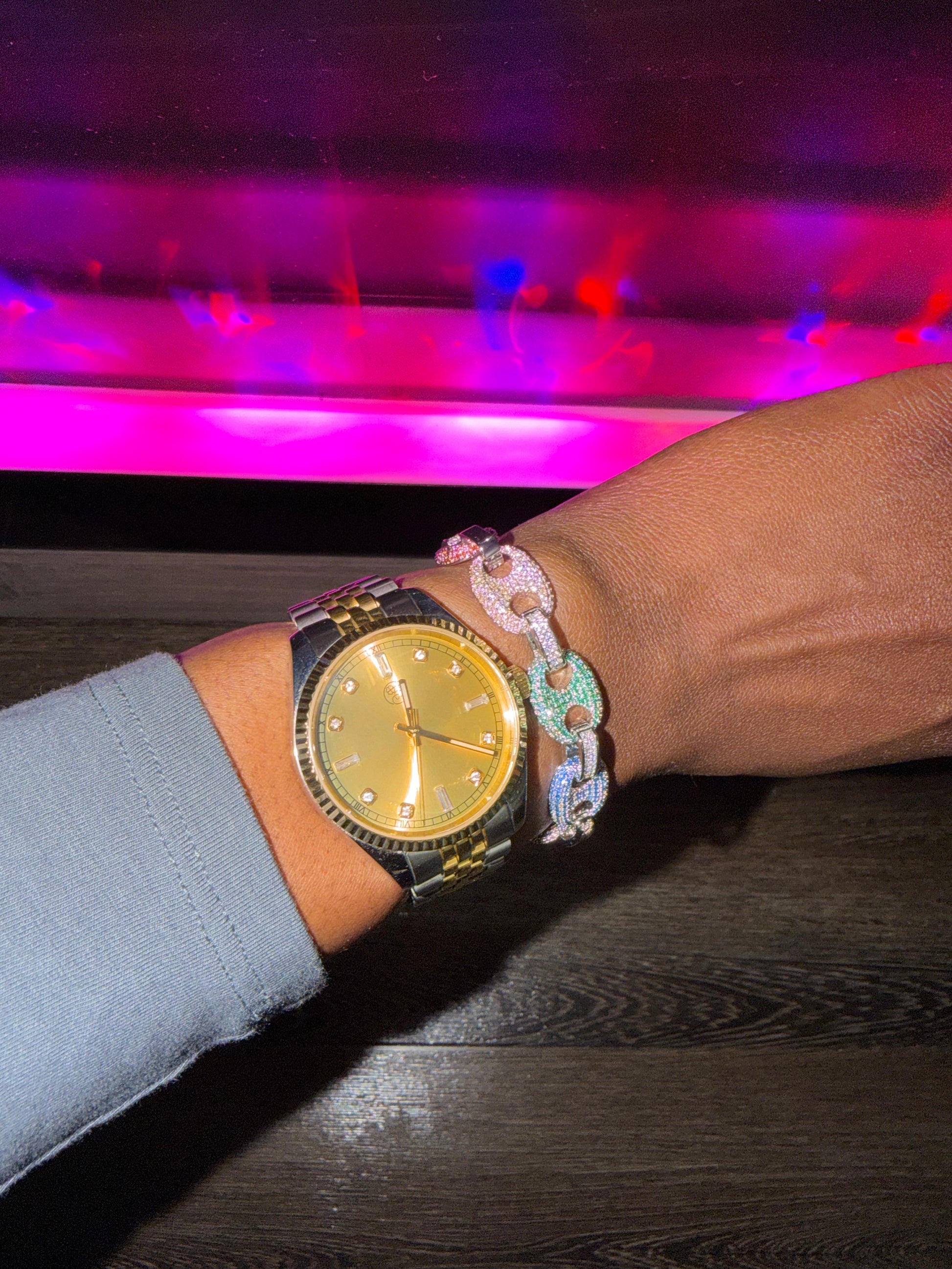 Gold dial mixed metal wristwatch on a wrist with coffee bean  bracelet 