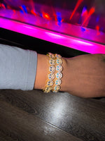 Person wearing multiple smiley face diamond bracelets.