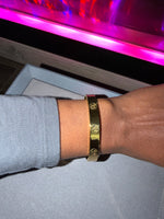 Gold bracelet on a wrist with engraving 