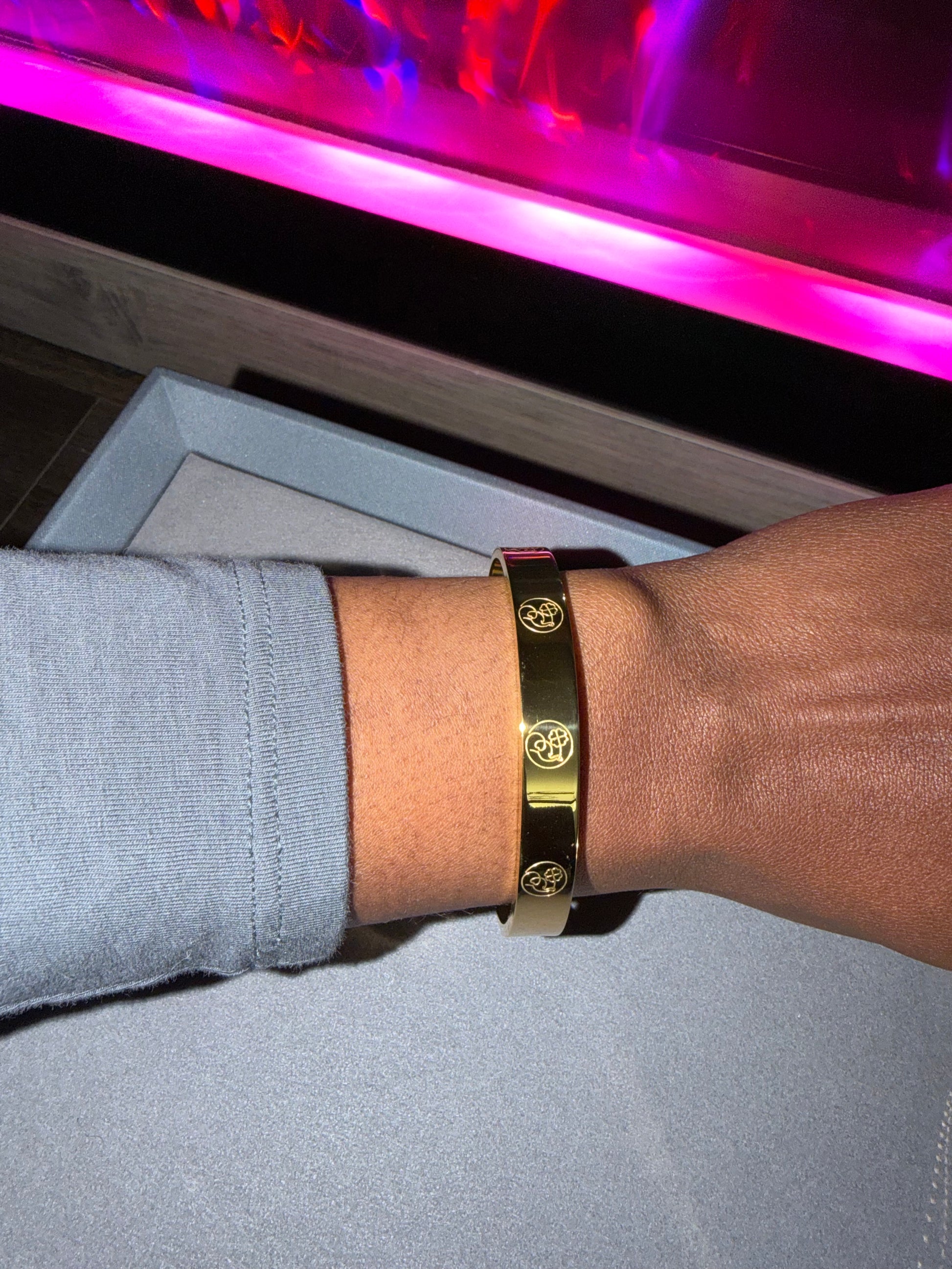Gold bracelet on a wrist with engraving 