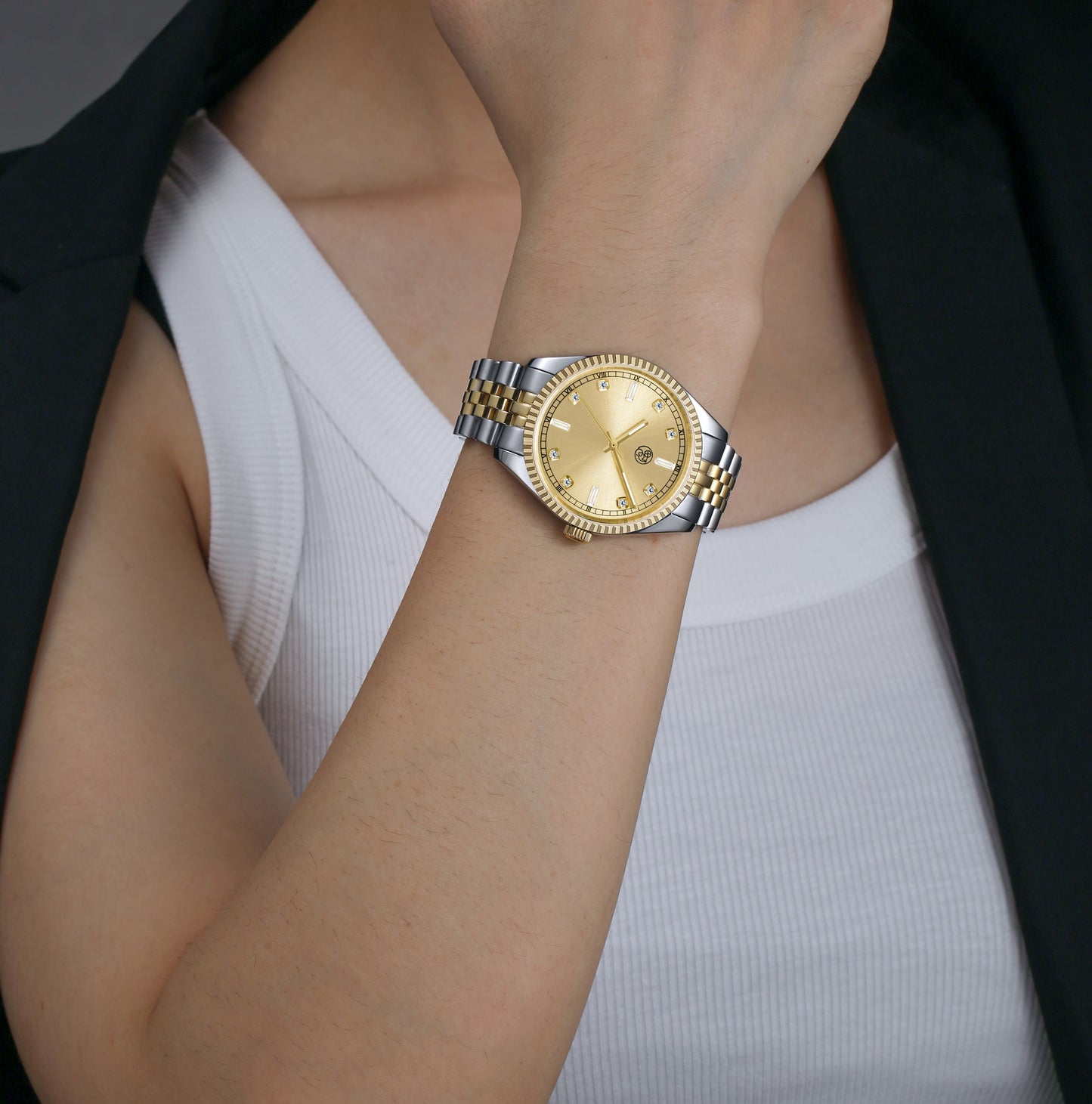 female in a two-tone watch with a gold dial and a mixed metal bracelet designed by RJ Royalty with lumious  baguette markers.