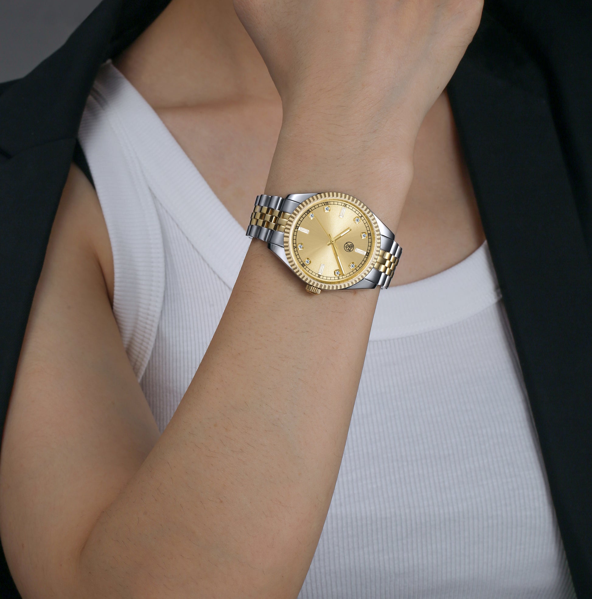 female in a two-tone watch with a gold dial and a mixed metal bracelet designed by RJ Royalty with lumious  baguette markers.