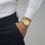 Two-tone 38mm stainless steel unisex watch with sunray gold dial and fluted bezel on male model, date window