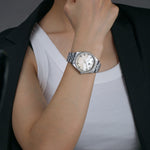 female entrepreneur wearing silver luxury mother of pearl dial watch with baguette markers.
