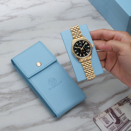 A luxury leather watch case in blue, shown holding a gold-banded watch. The case is presented with a visible RJ Royalty brand logo on the bottom right.