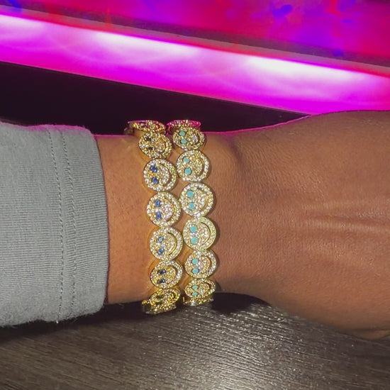 smiley bracelets stacked with blue diamonds