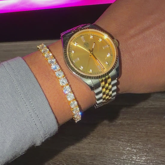 Gold tennis bracelet stacked with a rj royal gold dial watch 