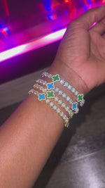 Stack of four blue and green clover bracelets in gold and silver on wrist